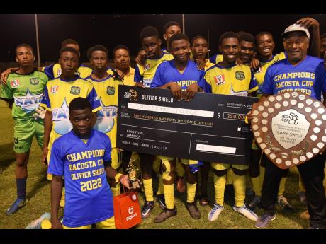 Credit: Ian Allen Clarendon College coach Lenworth Hyde (right) celebrate with the Olivier Shield with his players, after they defeated Jamaica College (JC) 3-0 at Stadium East yesterday.