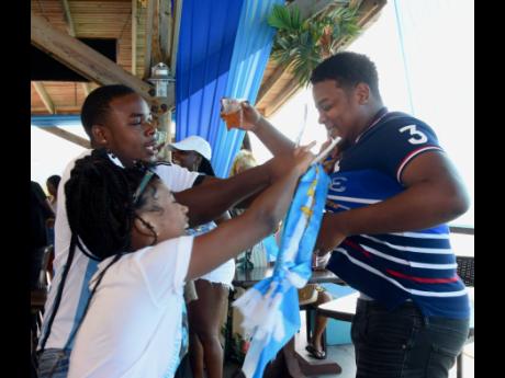 Joshua Vassell is being stripped of his France shirt by his friends, Kim Brown and Yonel Burnett. It ended up in the sea near Pier 1, Montego Bay, St James.
