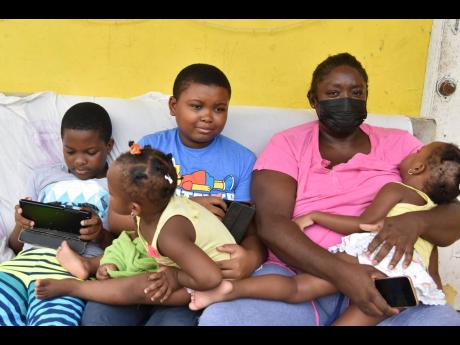 Miriam McDonald sits with her children (from left) Jhordanne and Jhadanne Thomas, and Jhanaye and Jhenaye Bent.