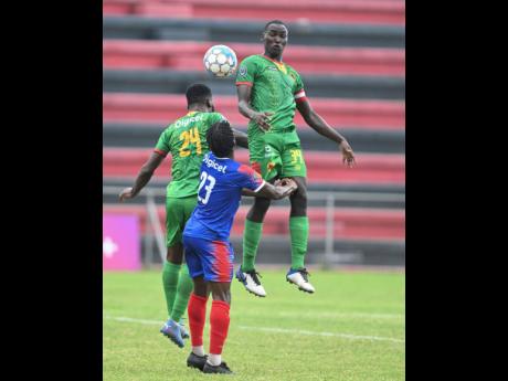 Humble Lion’s Rayland Paisley (left) heads the ball clear of Dunbeholden’s Nickoy Christian during a Jamaica Premier League match at the Anthony Spaulding Sports Complex on October 23, 2022.  At right is Afiba Chambers of Humble Lion. The game ended in a 0-0 draw. 