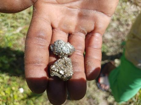 A resident shows off what some persons believe is the mineral pyrite, which is called ‘fools’ gold’ due to its resemblance to the precious element.