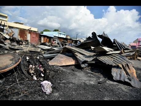 Credit: Kenyon Hemans Fire of unknown origin razed the Ray Ray Market in downtown Kingston. The market has been affected by several fires over the years.