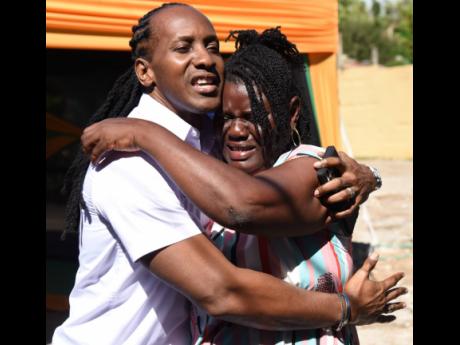 Moveta Clarke cries tears of joy as she gets a hug from Alando Terrelonge, member of parliament for St Catherine East Central. Clarke, who has been hobbled by three strokes, received a new home in Newland, Portmore, St Catherine on Wednesday, under the New Social Housing Programme.