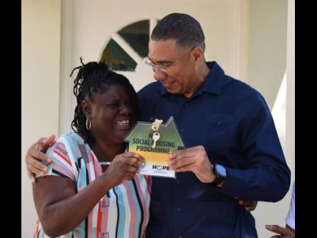 A grateful Moveta Clarke gets the keys to her new home from Prime Minister Andrew Holness.