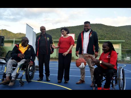 Credit: Kenyon Hemans Neville Sinclair (left) passes a ball to Alphanso Cunningham (right) to signal the opening of the new basketball court, valued $10 million, at the Sir John Golding Rehabilitation Centre in St Andrew on Monday. They were joined by Christopher Samuda, president of Jamaica Paralympics Association (second left), Jean Lowrie-Chin (centre), chairperson of Digicel Jamaica Foundation, and Ryan Foster, CEO and secretary general of the Jamaica Olympic Association.