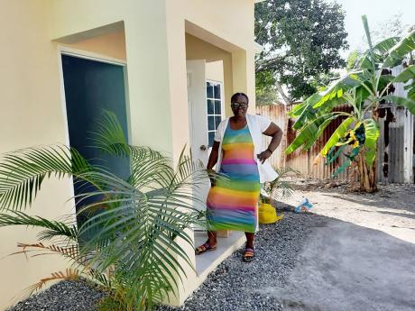 Judith Noble stands at the entrance to her new home in Calalloo Mews, St Andrew. 