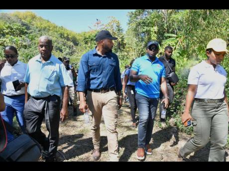 Entertainer Agent Sasco (centre) and Minister of Agriculture and Fisheries  Pearnel Charles Jr (second right, foreground) engage in discussion during last Thursday’s tour of the Mulberry Valley Estate in Friendship Gap, St Mary.