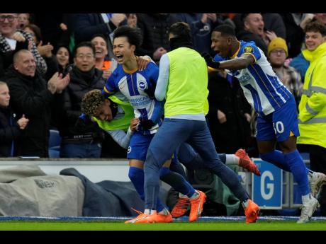 Brighton’s Kaoru Mitoma (left) celebrates after scoring their second goal in the FA Cup fourth-round match against Liverpool at the Falmer Stadium in Brighton, England, yesterday. Brighton won 2-1.