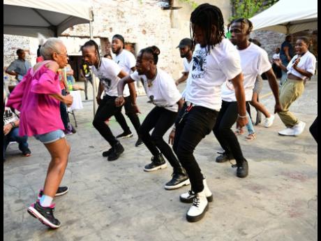 Credit: Gladstone Taylor Eighty-four-year-old Yvonne McCalla Sobers goes toe-to-toe with members of the Immortal Dancers at Kingston Creative’s ArtWalk in downtown Kingston yesterday.
