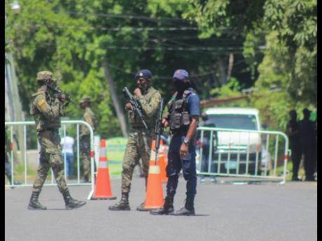 Credit: Ashley Anguin Members of the security forces at a zone of special operations checkpoint in Norwood, St James.