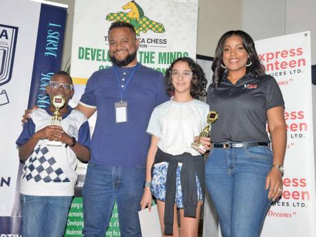Champion boy and girl at the Mona Preparatory School PTA Chess Tournament, Mona Prep’s Khaleel Johnson-Bartlett (left) and Kayla Moses (second right), from Creative Arts Learning Centre, display their first-place trophies alongside sponsorship representatives Ryan Foster, CEO, and Simone Foster, director, Express Canteen Services Limited, during the presentation ceremony at Mona Prep on Saturday.