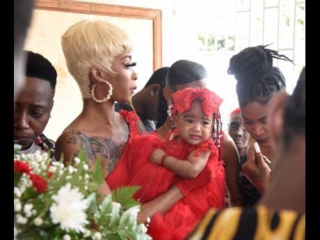 Findley’s spouse Tawana Lowther and the couple’s daughter Raveena are consoled by loved ones.
