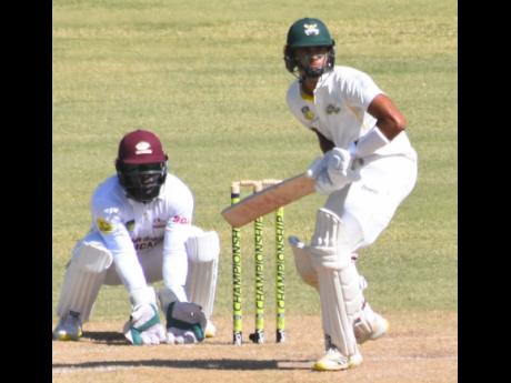 Jamaica Scorpions batsman Abhijai Mansingh prepares to play a shot while the Leeward Islands Hurricanes wicketkeeper Jahmar Hamilton looks on.