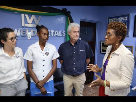 Danae Pryce (second left) gets words of encouragement from Lorretta Ricketts (right), acting principal of Merl Grove High School. Looking on are Tank-Weld’s Sarah Jardim and Bruce Bicknell.