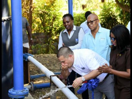 Minister without portfolio in the Ministry of Economic Growth and Job Creation, Senator  atthew Samuda, enjoys a sip of water from the newly commissioned Fraser Hill Storage Tank Replacement Project in St Thomas on February 8. Sharing the moment (from left) are Regional Manager for Kingston, St Andrew and St Thomas at the NWC, Dr Phillipa Campbell-Francis; former Mayor of Morant Bay, Councillor Michael Hue; and Member of Parliament for St Thomas Eastern, Dr Michelle Charles.