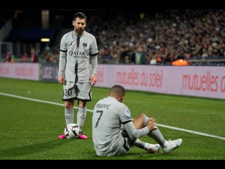 Paris Saint-Germain’s (PSG) Lionel Messi stands next to the injured Kylian Mbappe during the French League One football match against Montpellier at the State La Mosson stadium in Montpellier, France, February 1, 2023, which PSG won 3-1.
