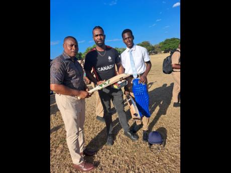 Principal of St Catherine High School, Marlon Campbell (left), tries out one of the bats donated by past student Aaron Johnson (centre). Looking on is current captain of the school’s Under-19 team, Winston Williams.
