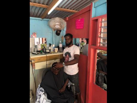 Balbow Saunders prepares to trim a customer.