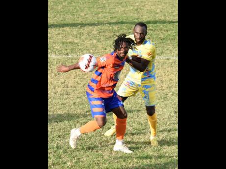 Allan Ottey (left) of Montego Bay United tries to hold off the challenge of Damion Binns of Waterhouse during the Jamaica Premier League football match at Waterhouse Mini-Stadium yesterday. Waterhouse won 3-0.