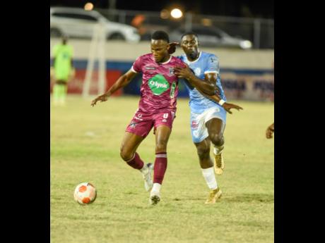 Earon Elliot (left) of Chapelton Maroons tries to hold off the challenge from Ricordo James of Faulkland during their Jamaica Premier League match at Ashenheim Stadium on February 6. Faulkland won 1-0.