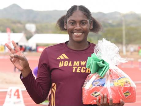 Holmwood’s Cedricka Williams enjoys the limelight after establishing a new Class I girls’ discus record of 54.01 metres at Central Champs yesterday at GC Foster College. 