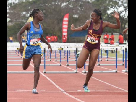 Credit: Ian Allen Kiara Meikle (right) of Holmwood Technical High wins the Class Two girls’ 100 metres hurdles final in a record 13.16 seconds at the Central Athletics Champions at GC Foster College on March 2. In a very close finish Hydel High’s Camoy Binger (left) was awarded the same time for placing second.