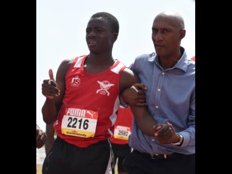 Garth Gayle, principal of Charlemont High School and president of the Jamaica Athletics Administrative Association, assists Delano Todd off the track as he had collapsed after winning the Class II boys' 800 metres final in 1.59.54 minutes last week.