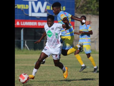 Chapelton Maroons’ Kristoff Graham (left) outpaces Waterhouse’s defender Romain Blake during their Jamaica Premier League encounter at the Waterhouse Stadium yesterday. Waterhouse won 3-2.