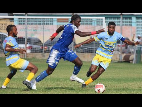 Credit: Lennox Aldred Mount Pleasant’s Trivante Stewart (centre) turns away from Waterhouse’s Kenly Deacon (left) and Ramone Howell during their Jamaica Premier League (JPL) encounter at Waterhouse Stadium yesterday. Waterhouse won 2-0.