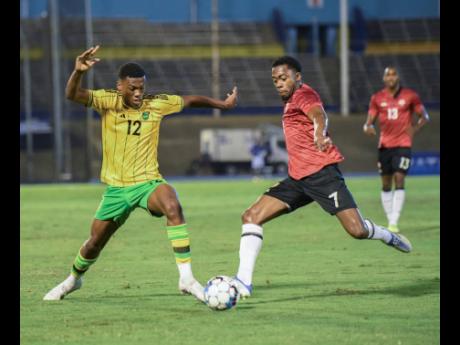 Jamaica’s Dujuan ‘Whisper’ Richards (left) contends with Trinidad and Tobago’s Noah Powder during the recent friendly international football match at the National Stadium, which ended in a 0-0 draw.