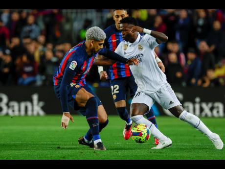 Real Madrid’s Vinicius Junior (right) and Barcelona’s Ronald Araujo fight for the ball during their Spanish La Liga match at the Camp Nou stadium in Barcelona on Sunday. Barcelona won 2-1.