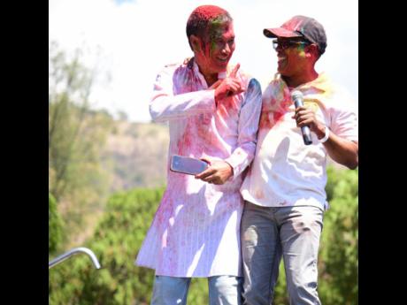 Jamaica’s Dr Norman Dunn (right), minister of state in the Ministry of Industry, Investment and Commerce, celebrates with India’s High Commissioner to Jamaica Rungsung Masakui, at the Holi festival held at the India-Jamaica Friendship Garden, Hope Royal Botanical Gardens, St Andrew, on March 12.