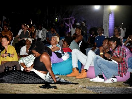 Several persons gather to watch short films at the Shot List film festival held at Hope Gardens in St Andrew on Sunday.