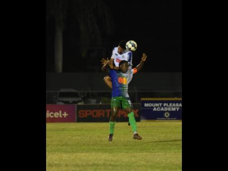 Montego Bay United’s Johann Weatherly (front) tried to block the header of Mount Pleasant’s Odane Murray during their Jamaica Premier League (JPL) football match at the Montego Bay Sports Complex last night. The match drew 2-2.