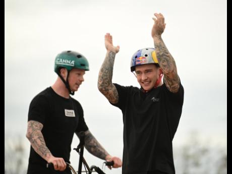 Freestyle BMX performer Kieran Reilly (right) acknowledges the crowd after entertaining patrons with gravity-defying stunts at Jamaica Stunt Fest. At left is James Jones, a talented professional BMX rider.