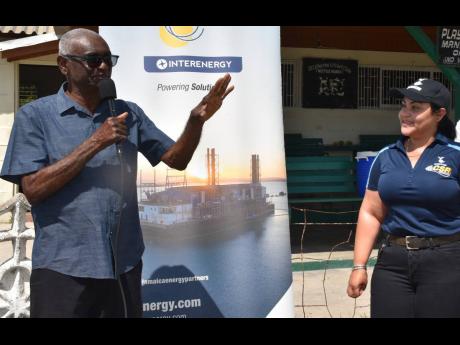 Credit: Contributed President of the St Catherine Cricket Association Milholland Barker (left) addresses the recent launch of the Jamaica Energy Partners (JEP) Cricket League at Chedwin Park while JEP’s Director of Corporate Affairs, Shared Values & Marketing, Melissa Newman, listens.