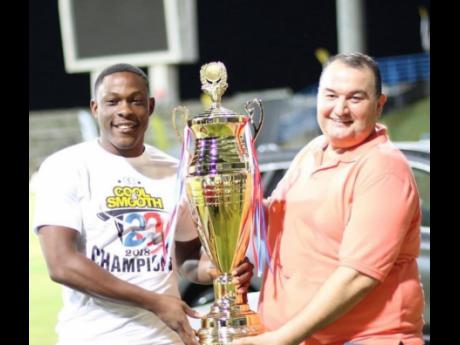 Jamaica’s Sheldon Cottrell (left) posing with the Cool & Smooth T20 trophy, which he won with Bethesda Golden Eagles in 2018. Sharing the occasion is Amer Hourani, director of Cool & Smooth T20.
