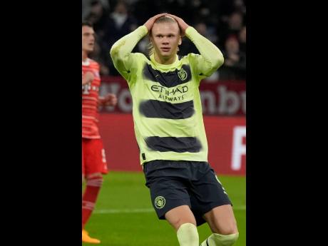 Manchester City’s Erling Haaland reacts after missing a penalty kick during their Champions League quarterfinal second-leg football match against Bayern Munich at the Allianz Arena stadium in Munich, Germany, yesterday. The match ended 3-3 with City advacing to the semifinals 5-3 on aggregate.