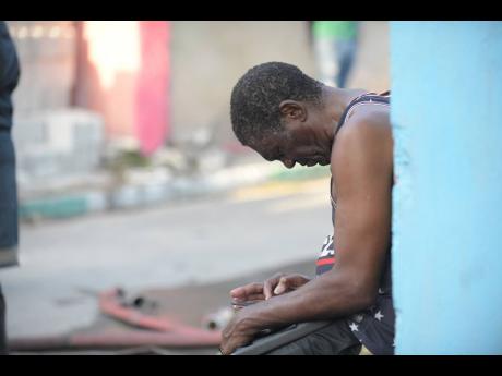 Tyrone Parker, one of the residents displaced by yesterday’s fire on Tex Lane touches his cell phone, the only thing he saved.