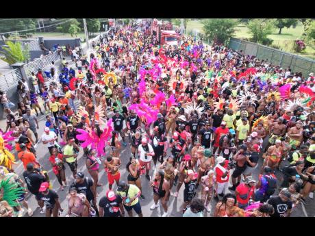 Carnival revellers move along Hope Road last Sunday.