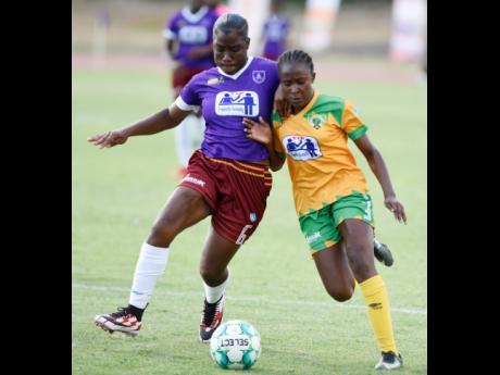Credit: Nicholas Nunes Excelsior’s Ricquanna Richards (right) battles with Aaliyah Martin of Holmwood Tech during their ISSA/TIP Friendly Society Schoolgirls final at Stadium East yesterday. Excelsior won 8-0.