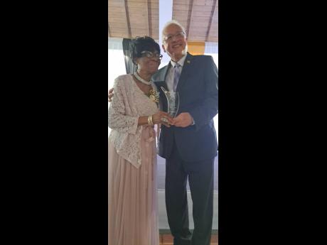 Luna Derica Bailey receives her award for 45 years of service to St Catherine as a justice of the peace from Justice Minister Delroy Chuck.