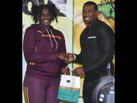 Cedricka Williams (left) receives her Team Jamaica Bickle (TBJ) award from Jamaica Olympic Games gold medallist Yohan Blake after she won the girls’ discus at the Penn Relays, Philadelphia, Pennsylvania, United States in a record.