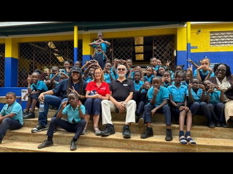 Students of the Bob Marley Primary and Junior High School pose with (from left) Sean ‘Contractor’ Edwards, Diane Pollard and Paul Issa who all toured the institution this week. At far right is teacher Antoinette Meikle-Greaves. The children will take part in the Michael Bolton concert on May 27.