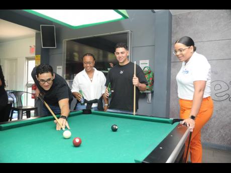 During a fierce game of pool, Steven McConnell (left) attempts a shot to take the lead against his brother Fraser McConnell (second right), rally cross driver, as Gillian Lee (second left), winner of the Heineken 0.0’s Formula 1 campaign, and Amoye Phillpotts-Brown, brand manager of Heineken watch at the Heineken 0.0 Miami Grand Prix Send-Off held at the Red Stripe Vibes Room at the Red Stripe HQ Spanish Town Road, St Andrew, on Thursday.