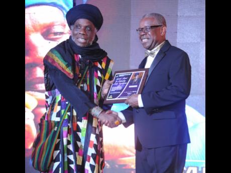 Credit: Nicholas Nunes/Photographer Dr Ephraim Martin (right), president of Martin’s International, producer of IRAWMA, presents Mutabaruka with a special award for outstanding media contribution.