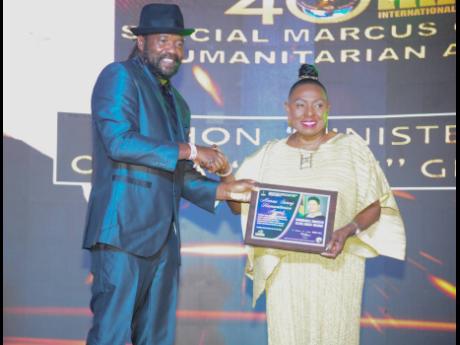Credit: Nicholas Nunes/Photographer Reggae star Tony Rebel presents Culture Minister Olivia Grange with the Marcus Garvey Humanitarian Award.