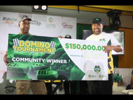 Supreme Ventures Limited  Executive Chairman Gary Peart (right) poses with Leroy Cooper, the Supreme Domino Master Series Champion of the May Pen Division, at Hotel Versalles in May Pen, Clarendon, on Sunday.