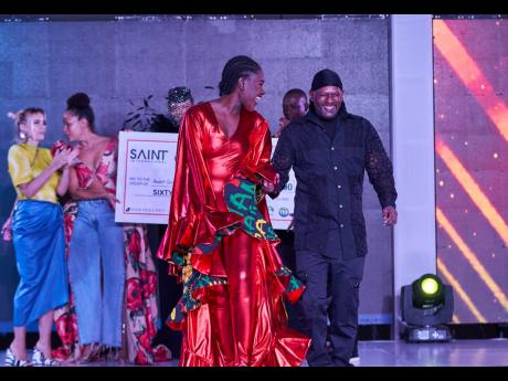 Credit: Contributed An exuberant Janseen Graham (right), after being announced SAINT International’s Avant Garde Designer of the Year, hits the catwalk with model Marieka Marston outfitted in his winning design, ‘Jamrock Fusion’, at the competition held last month at the AC Hotel Kingston.