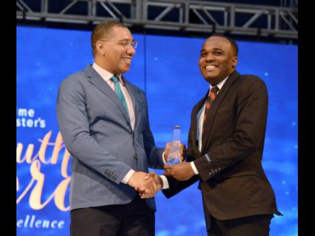 Credit: File Prime Minister Andrew Holness (left) presents Abka Fitz-Henley with a Youth Award in 2018.